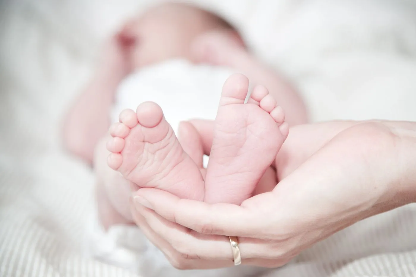 Manos de una madre sosteniendo los pies de su recién nacido